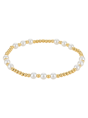 The Kinsey Designs Graduating Pearl Stretch Bead Bracelet 4mm features evenly spaced white pearls and gold beads, adding timeless charm to any look. Elegantly displayed on a white background.