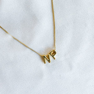 Kinsey Designs’ Nurse Charm Necklace with gold filled "N" and "P" letter charms is displayed on white fabric—a meaningful gift for nurses or a thoughtful PAC donation idea.