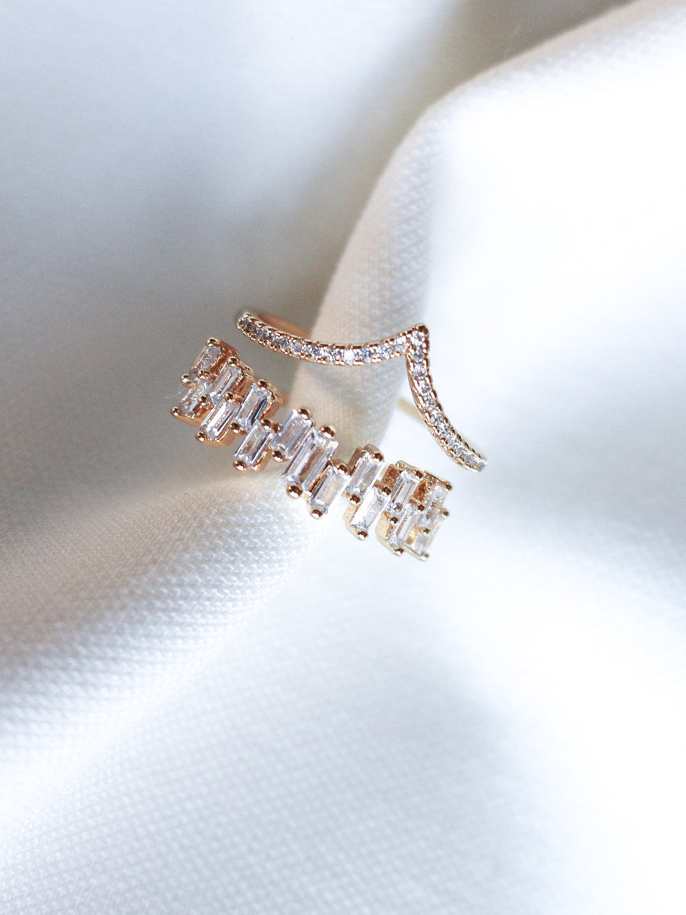 The Ines Ring by Kinsey Designs features gold plating with rectangular and round cubic zirconia stones, displayed on white textured fabric.