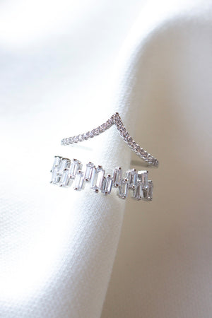 Two Ines Ring Silver pieces by Kinsey Designs, featuring sparkling Cubic Zirconia, displayed on a soft white fabric background.