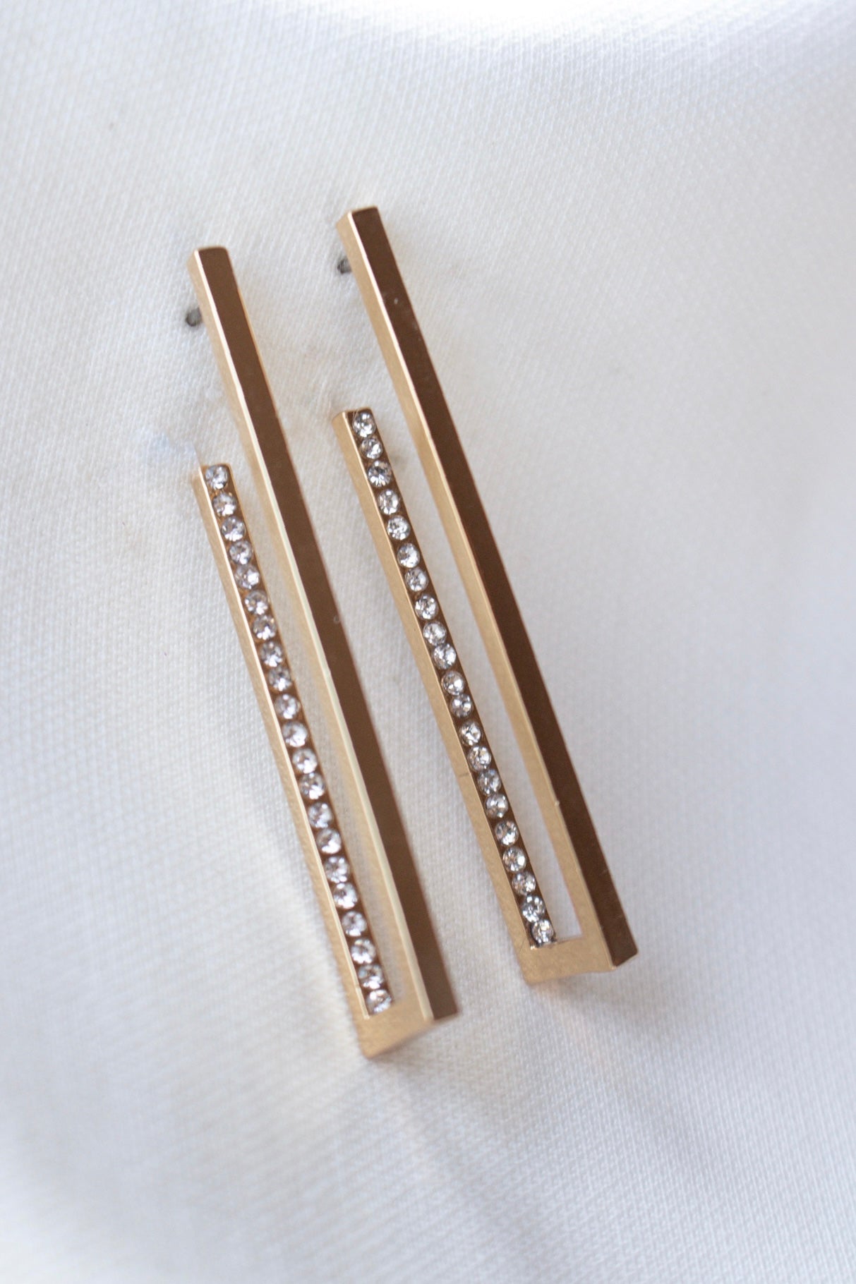 The Inside Job Hoop by Kinsey Designs Archives features gold-filled rectangular earrings adorned with a row of sparkling cubic zirconia, elegantly displayed on white fabric. Ideal for those seeking sample sale prices on stylish earrings.