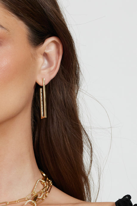 Close-up of a woman wearing Kinsey Designs Archives’ Inside Job Hoop gold-filled earrings and a gold chain necklace against a light background—perfect picks for our upcoming sample sale.