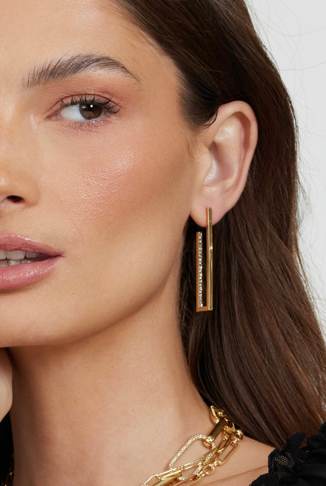 Woman wearing the Inside Job Hoop by Kinsey Designs Archives and a gold chain necklace, close-up on face and jewelry. Discover stunning styles like these gold filled earrings at our sample sale.