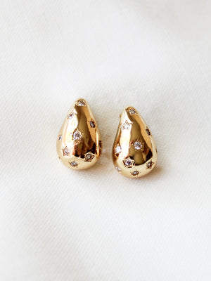 The Kline Dome Earring by Kinsey Designs Archives features gold-filled teardrops with small clear stones, shown on a soft white fabric. Earring length: 0.75 inches.
