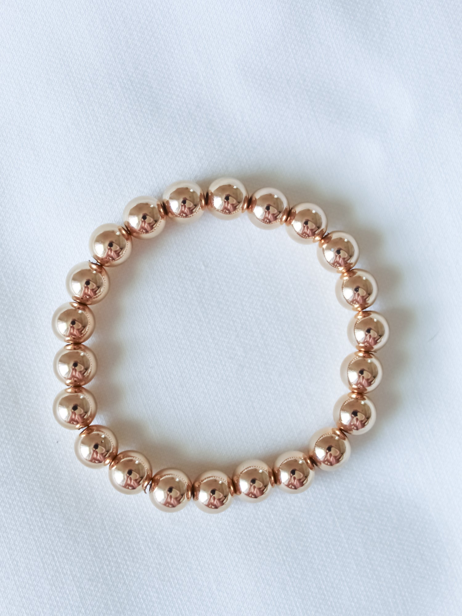 The Kinsey Designs Liam Stacking Bracelet, available in multiple sizes, is shown arranged in a circle on white fabric.