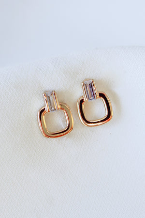 Kinsey Designs Lucky Post earrings feature gold-filled and crystal studs in geometric shapes, each measuring 0.5" long, shown on a white fabric background.