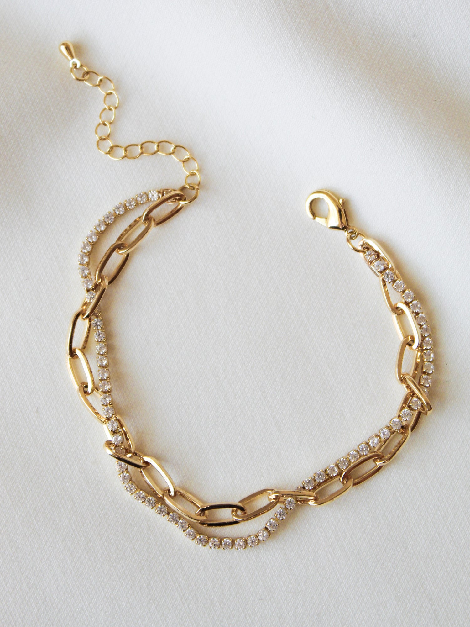 The Kinsey Designs Marc Tennis Bracelet features a single strand of rhinestones set in gold fill, shown against a white fabric background.