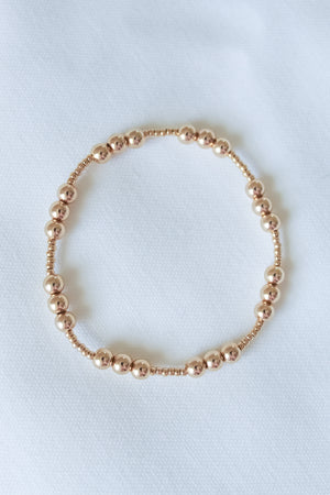 The Mia Bracelet by Kinsey Designs, shown in a circular arrangement on white fabric, features an adjustable stretch design and comes in multiple sizes—ideal for finding your perfect fit at a sample sale.