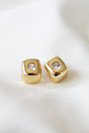 The Mick Earring by Kinsey Designs: gold filled square studs with clear center gemstones, shown on white fabric. Add a touch of elegance—shop our sample sale now! All items are final sale.