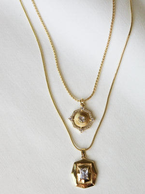 The Orion Detachable Necklace by Kinsey Designs features two gold filled geometric pendants—one round with a diamond, one hexagonal with a square stone—for a chic, modern layered look.