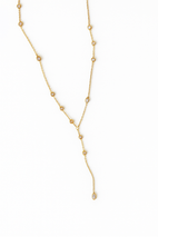 The Kinsey Designs Pozey Lariat is a delicate gold filled necklace with spaced round gemstones and a single dangling drop for subtle elegance.