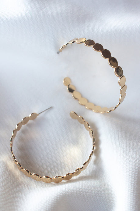 The Round and Round Hoop earrings by Kinsey Designs Archives feature a scalloped gold-filled design, 2" wide, shown on white satin fabric.