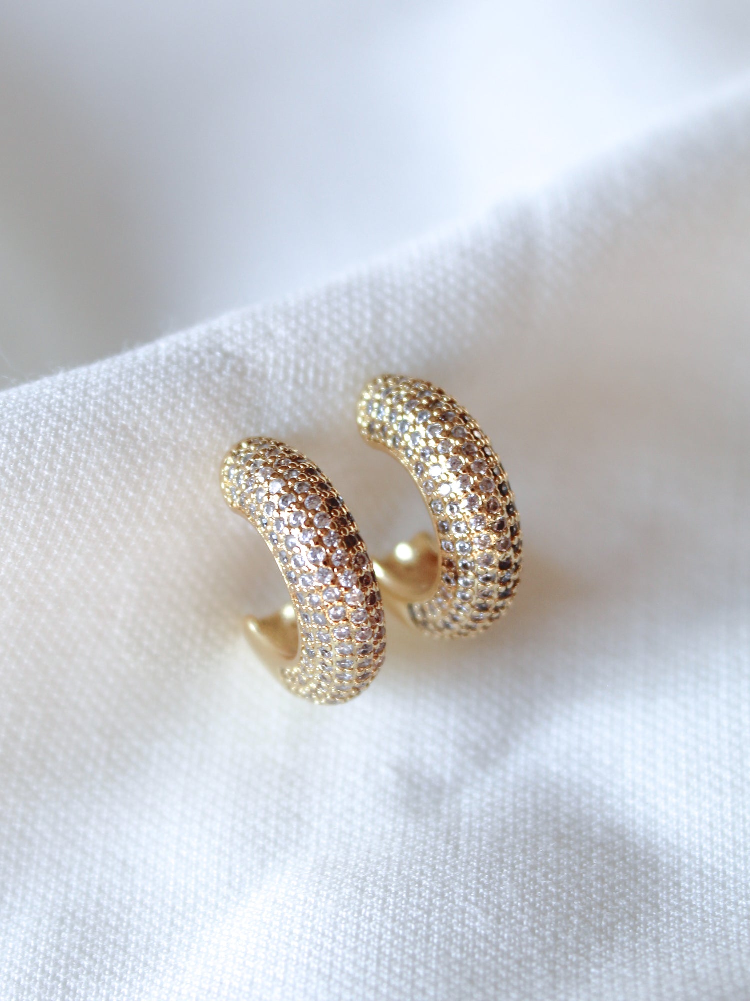 Kinsey Designs' Sax Hoop gold filled earrings, .85" diameter, feature small gemstones and are shown on a white fabric background.