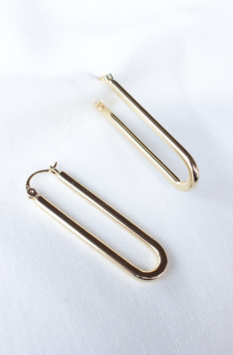 The Kinsey Designs Archives Tate Hoop earrings—a pair of gold filled U-shaped hoops—are shown on a white fabric background. FINAL SALE item.