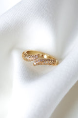 The Venetia Ring by Kinsey Designs, featuring sparkling stones, is elegantly showcased on a soft white fabric background.