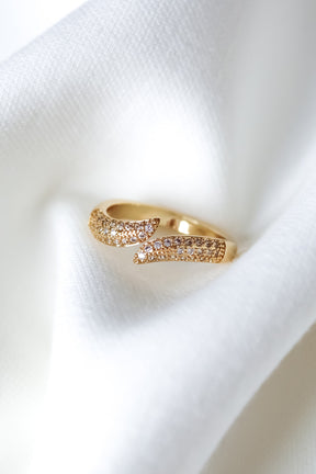 The Venetia Ring by Kinsey Designs, featuring sparkling stones, is elegantly showcased on a soft white fabric background.