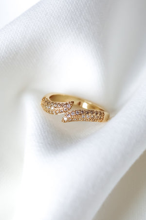 The Venetia Ring by Kinsey Designs, featuring sparkling stones, is elegantly showcased on a soft white fabric background.