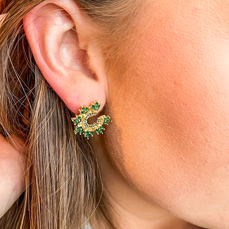 Close-up of a woman’s ear wearing Kinsey Designs Archives’ Vina Stud earrings—gold filled, floral cluster shape with green gemstone accents, each measuring 0.65 inch in diameter.