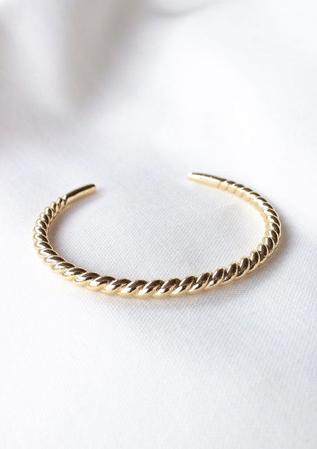 The Kinsey Designs Fallon Mama & Baby Cuff Set features an adjustable, nickel-free, gold-filled twisted open cuff—ideal for daily wear. Shown on white fabric.