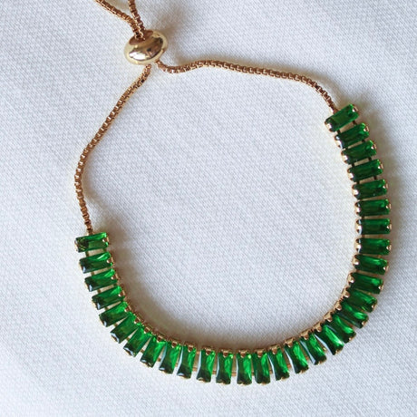 Gold chain necklace with rectangular green gemstones on a white fabric background, pairs perfectly with your favorite Kinsey Designs Archives Ivy Bracelet.