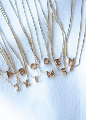 The Kinsey Designs Collection Kinsey Slide Initial Necklace featuring the letter C is displayed on a white fabric background.