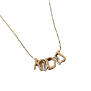 Kinsey Designs' Gold Letter Slide Charms form the initials "KDJ" on this customizable necklace, featuring a delicate chain and stylish letter pendants against a white background.