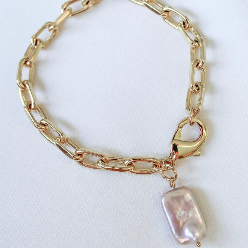 The Coral Pearl Bracelet by Kinsey Designs Archives features a gold chain with a rectangular mother-of-pearl charm, shown on a white background.