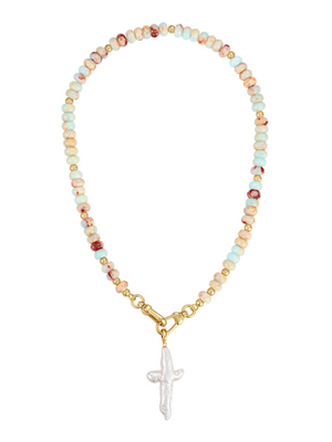 The Aurelium Cross Gemstone Necklace by Kinsey Designs features turquoise gem beads, a gold clasp, and a white pearl cross pendant at the center.