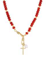 The Katherine Cross Gemstone Necklace by Kinsey Designs features red and gold beads, carnelian accents, a gold cross pendant, and a single white pearl charm.