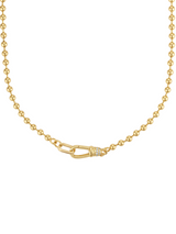 The Juniper Ball Chain Necklace by Kinsey Designs features gold beading, a distinct oval front clasp, and a delicate wrapped center detail.