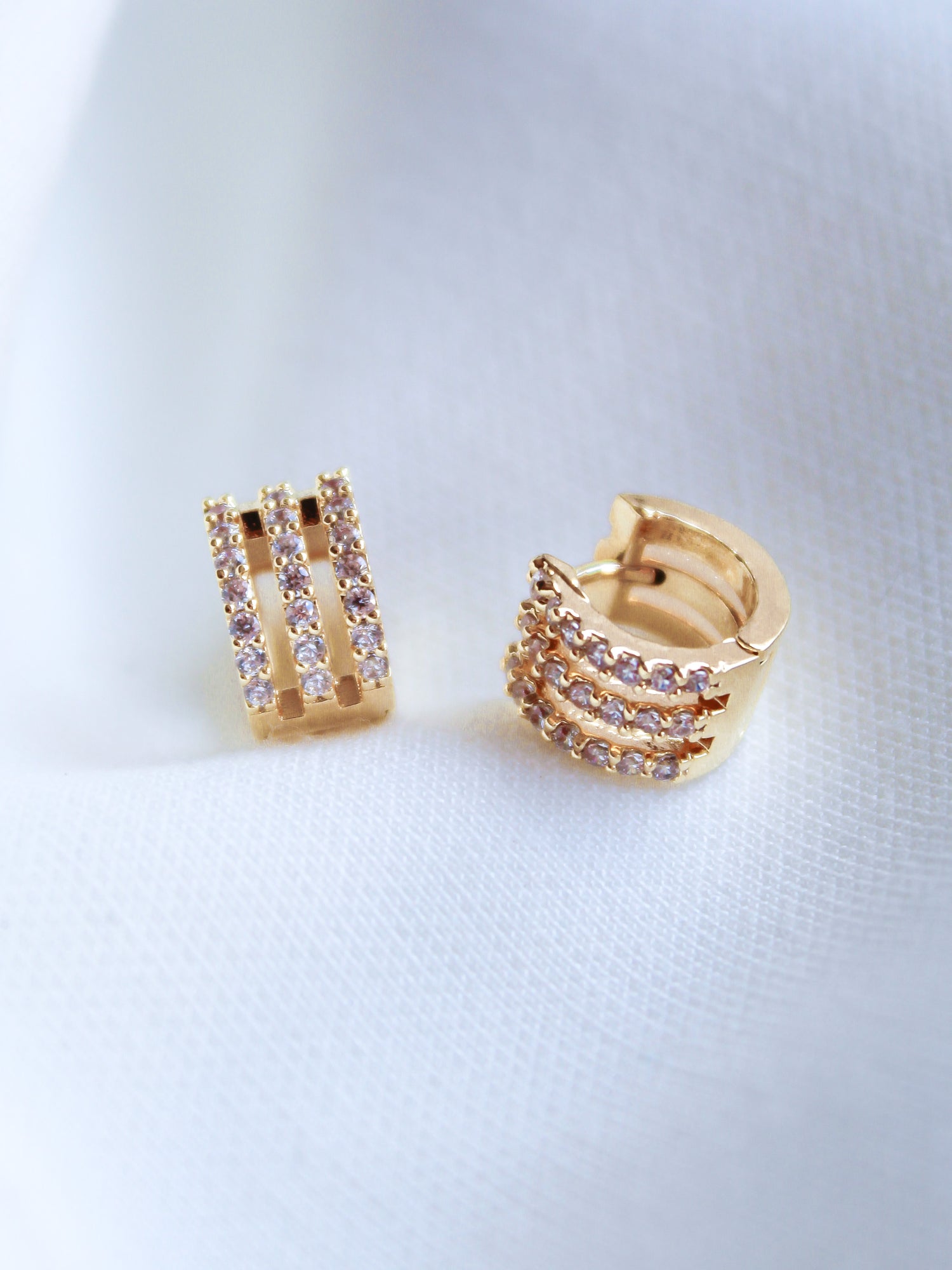 The Bri Huggie by Kinsey Designs Archives features three rows of small, sparkling cubic zirconia stones set on 14k gold plated hoops.