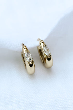 The Claudia Huggie by Kinsey Designs Archives features gold filled hoops with marquise cubic zirconia stones (.75" circumference), shown on a white fabric background.