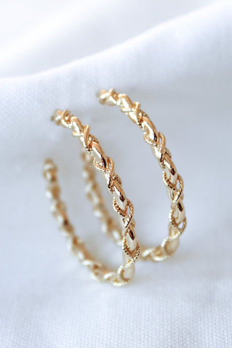 The Cru Hoop by Kinsey Designs Archives features two gold filled hoops with a twisted, chain-like design and 1.25" diameter, shown on a white fabric background.