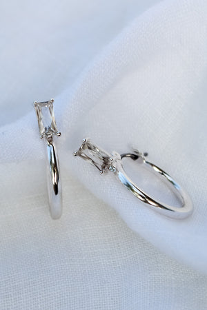 The Darra Mini Silver hoop earrings by Kinsey Designs Archives feature rectangular Cubic Zirconia, crafted from rhodium-plated brass, measure 3/4" in diameter, and are elegantly displayed on white fabric.