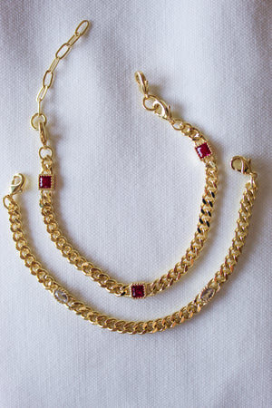 The Kinsey Designs Dublin Bracelet (3 in 1), featuring gold-filled chains with gemstone and cubic zirconia accents, rests on a white fabric background.