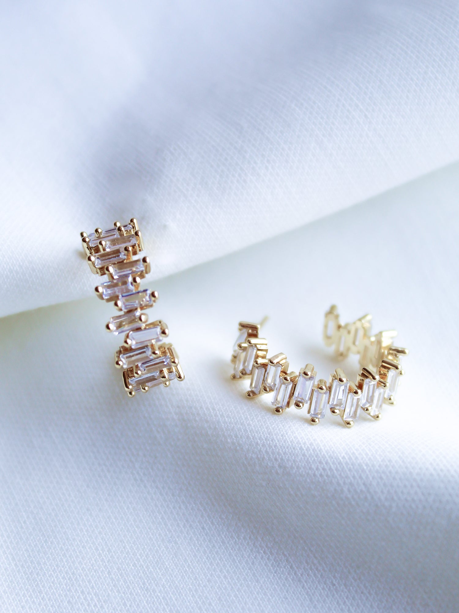 The Ettie Hoop by Kinsey Designs Archives features 1" gold filled earrings with rectangular cubic zirconia stones in a row, shown on white textured fabric.