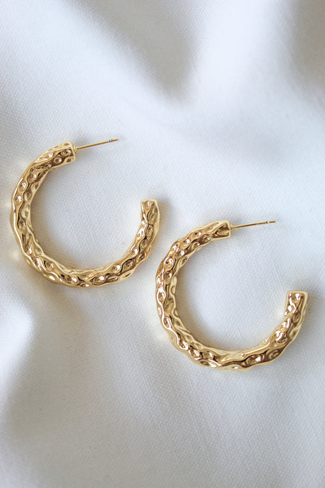 The Hammer Hoop by Kinsey Designs Archives features gold filled textured hoops, 1.5" in diameter, displayed on a white fabric background.