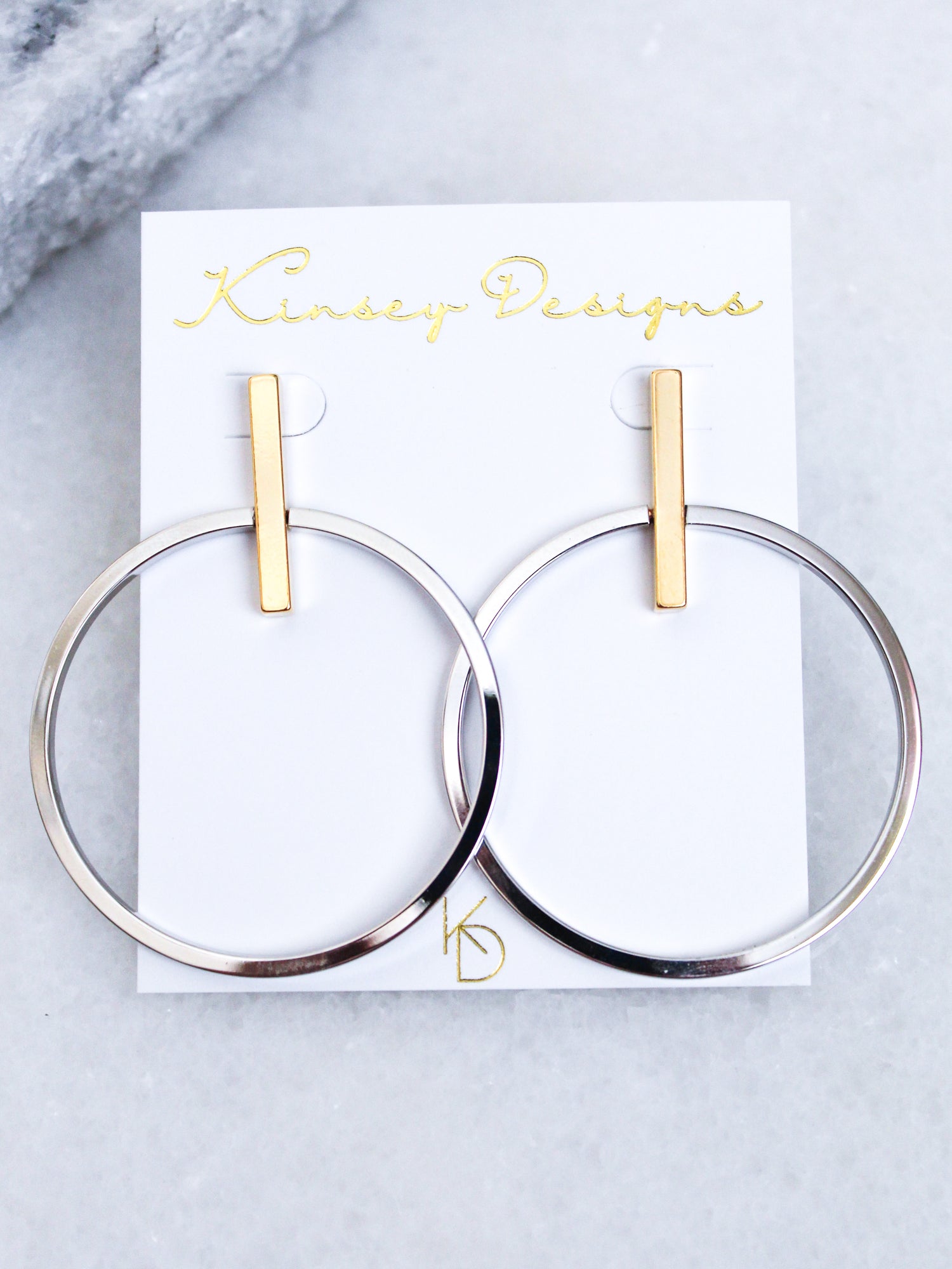 Jocelyn - Mixed Metals gold plated hoop earrings, 2” wide by 2.5” long, from Kinsey Designs Archives, shown on a white display card.