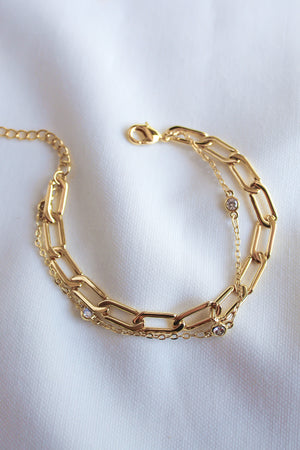 The Lisbon Bracelet by Kinsey Designs Archives features gold-filled rectangular links with small round gemstones. This elegant 6.5" chain is displayed on white fabric—a timeless addition to your gold jewelry collection.