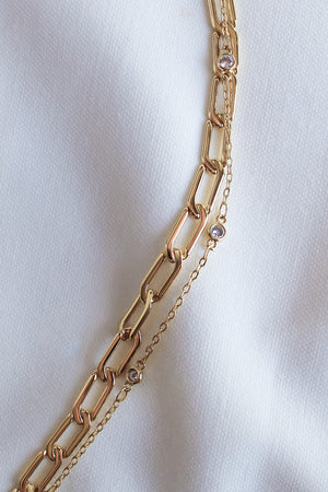 The Lisbon Bracelet by Kinsey Designs Archives rests elegantly on a white fabric background, showcasing its delicate design and sparkling details.