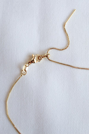 A close-up of the Kinsey Designs Archives MAMA Slide Necklace, a 14k gold filled chain with an adjustable Italian closure and lobster clasp, displayed on a white textured background.