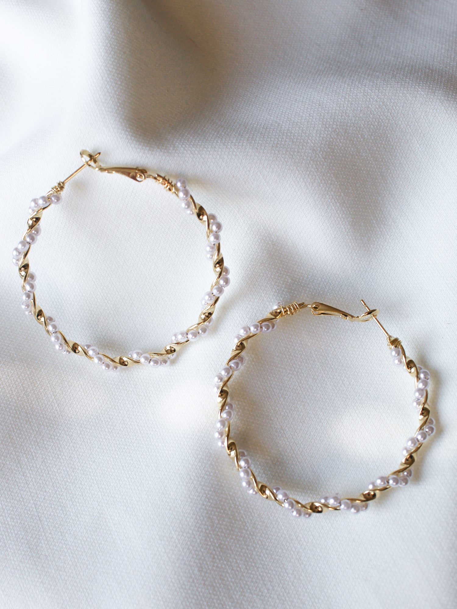 The Mac Hoop by Kinsey Designs Archives features gold filled hoops with a 2" diameter and small white pearls, displayed on a soft white fabric background.