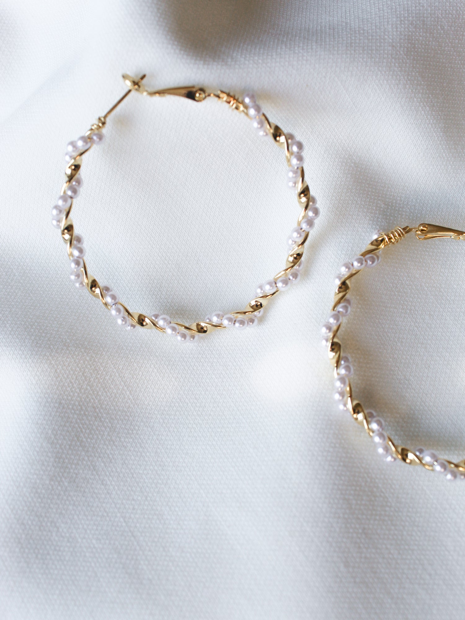 The Mac Hoop by Kinsey Designs Archives features gold-filled hoops with small white pearls, 2" in diameter, shown on a soft white textured fabric background.
