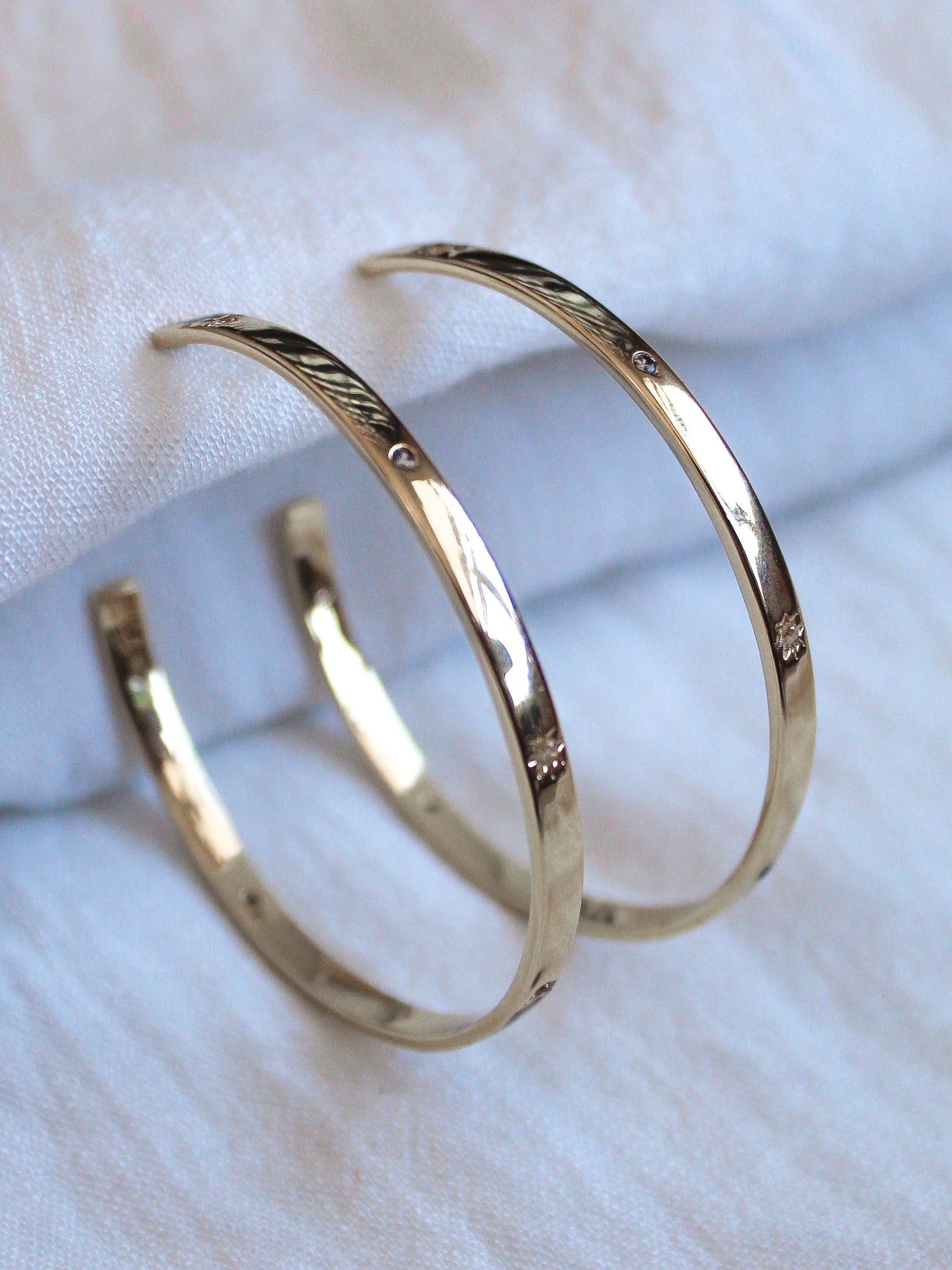 The Molly Hoop earrings by Kinsey Designs Archives are showcased on a soft white fabric background.