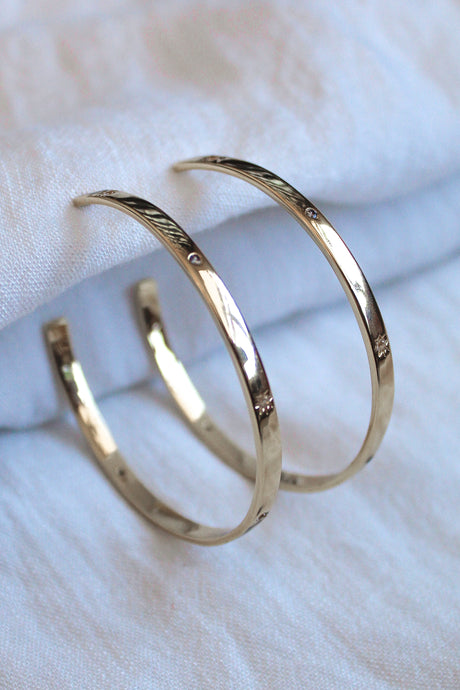 The Molly Hoop earrings by Kinsey Designs Archives are showcased on a soft white fabric background.