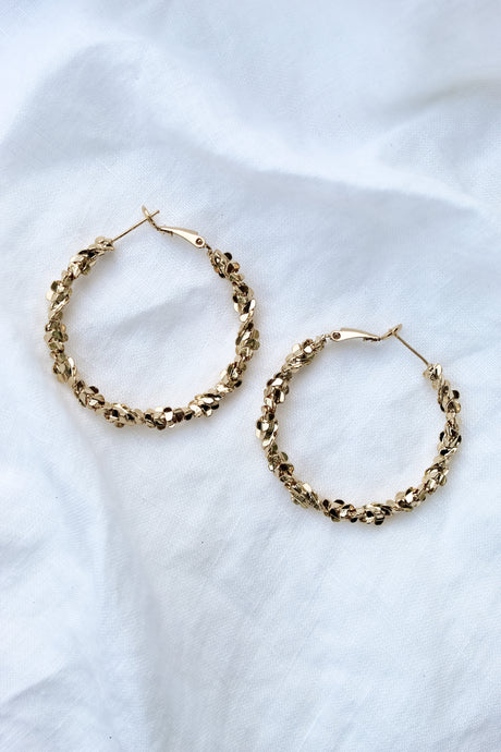 The Reese Hoop by Kinsey Designs Archives, featuring gold filled textured hoops with a 1.5" diameter, displayed on soft white fabric.