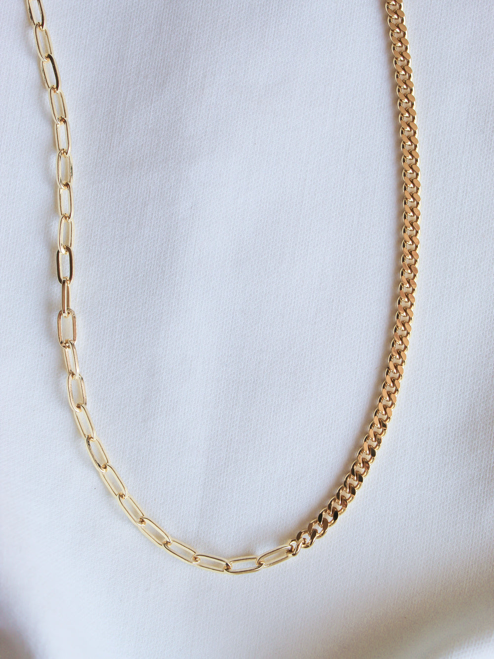 The Saxon Necklace by Kinsey Designs Archives features two bold gold-filled chain styles, elegantly displayed on a white fabric background.