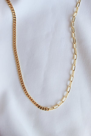 The Saxon Necklace by Kinsey Designs Archives features bold gold-filled mixed links, making a statement chain displayed on a white fabric background.