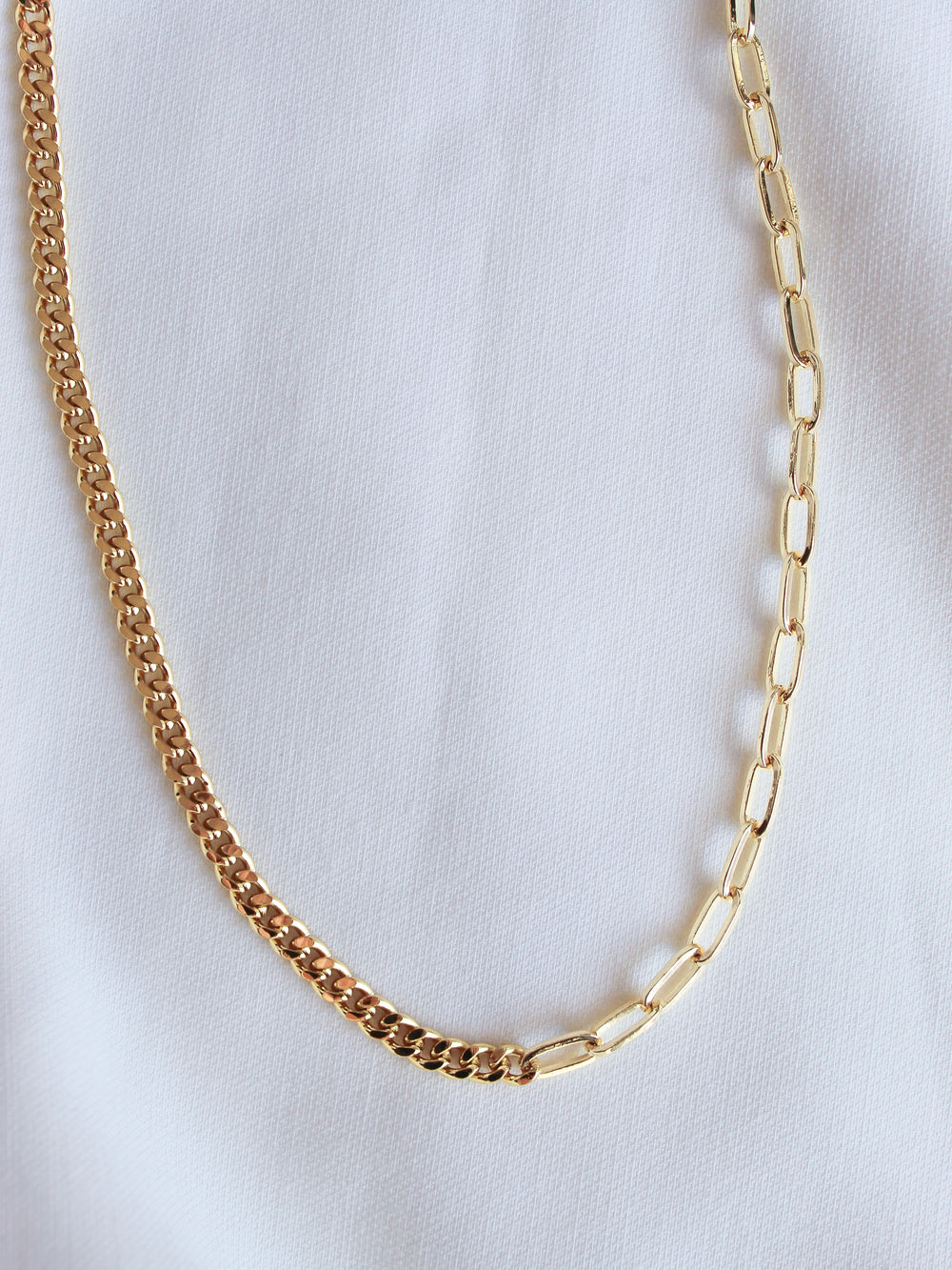 The Saxon Necklace by Kinsey Designs Archives is displayed on a white fabric background alongside another bold chain necklace.