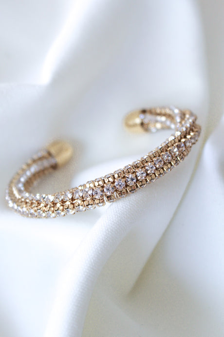 The Smog Cuff by Kinsey Designs Archives is a 16k gold plated brass adjustable bracelet with sparkling Cubic Zirconia, displayed on a white textured fabric background.